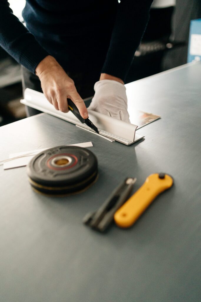 Découpe précise d'un tirage photographique à la latte et au cutter dans l'atelier Sel de Pixel à Rennes.
